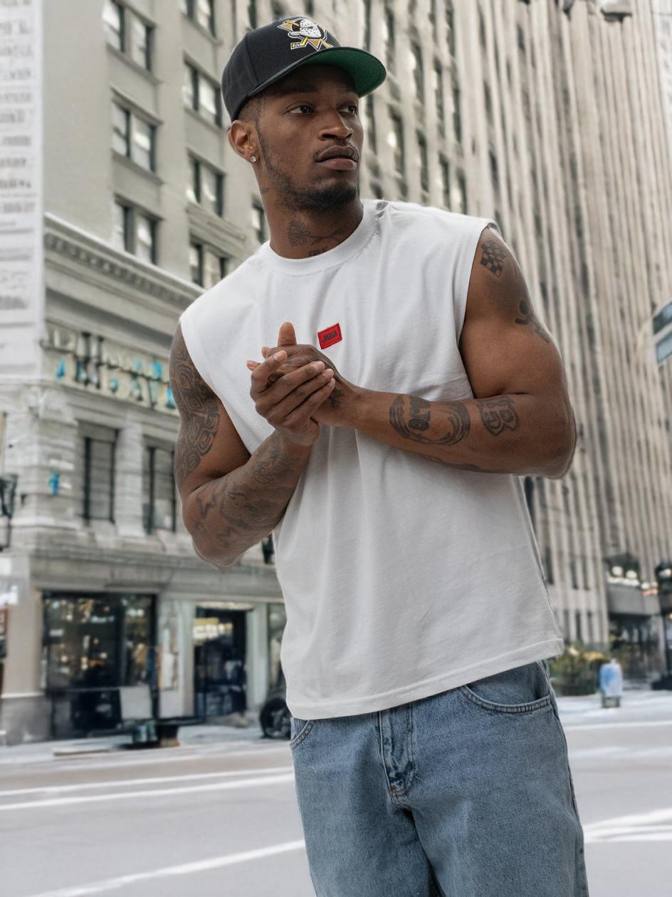 Biała koszulka bez rękawów (sleeveless) męska Jigga Wear z czerwoną naszywką, idealna na gorące letnie dni 2026.
